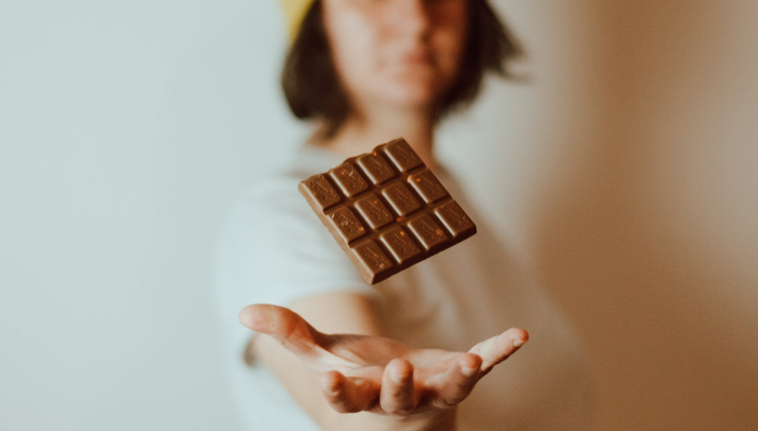 Close up of person catching bar of chocolate in hand